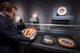 Ông Bernard Piguet, Giám đốc nhà đấu giá Piguet, cầm chiếc đĩa gốm của danh họa Pablo Picasso. (Nguồn: AFP)