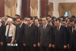 Các đại biểu dành phút mặc niệm tiễn đưa nguyên Chủ tịch nước Trần Đức Lương tại Thành phố Hồ Chí Minh. (Ảnh: Hồng Giang/TTXVN)