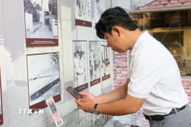 Du khách quét QR để tìm hiểu thông tin tại Nhà trưng bày thân thế, sự nghiệp Chủ tịch Tôn Đức Thắng, nằm trong Khu lưu niệm Chủ tịch Tôn Đức Thắng, thuộc xã Mỹ Hòa Hưng, tỉnh An Giang. (Ảnh: Công Mạo/TTXVN)