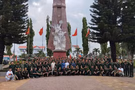 Đoàn cựu chiến binh phía Bắc chụp ảnh kỷ niệm tại Đài tưởng niệm Đăk Tô. (Nguồn: Vietnam+)