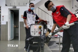 Các nhân viên kiểm tra khí thải xe máy. (Ảnh: Tuấn Đức/TTXVN)