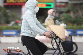 Người dân Thủ đô trang bị áo chống rét khi tham gia giao thông. (Ảnh: Thanh Tùng/TTXVN)
