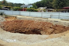 Tại vị trí hố sụt tại Km80+050 Quốc lộ 3B đã cơ quan chức năng tỉnh Bắc Kạn quây kín tôn để đảm bảo an toàn cho người và vật nuôi... (Ảnh: Nguyễn Công Hải/TTXVN)