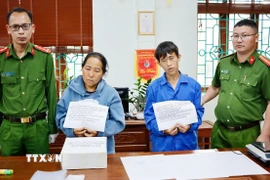 Hai đối tượng Giàng Thị Lâu và Sùng A Súa cùng tang vật phạm tội là 8 bánh heroin. (Ảnh: TTXVN phát)