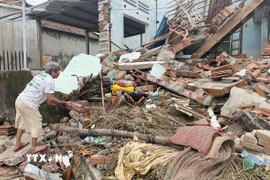 Người dân dọn dẹp nhà cửa bị sập do mưa lũ gây ra. (Ảnh: Tường Quân/TTXVN)