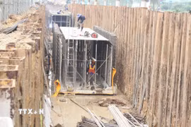 Công nhân tranh thủ thời tiết thuận lợi, đẩy nhanh tiến độ các hạng mục trọng điểm. (Ảnh: Nguyễn Thắng/TTXVN)