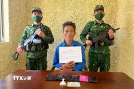 Đối tượng Sùng A Cở và tang vật vụ án. (Ảnh: TTXVN phát)