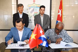 Ông Nguyễn Khắc Hoàng, Giám đốc công ty Hoàng Gia Việt, và đại diện của công ty nông nghiệp Alquizar, thuộc Tập đoàn doanh nghiệp Nông Lâm nghiệp Artemisa của Cuba, ký hợp đồng hợp tác. (Ảnh: Việt Hùng/TTXVN)