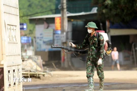 Lực lượng Sư đoàn 324 phun hóa chất khử trùng tại xã Mường Xén. (Ảnh: Văn Tý/TTXVN)