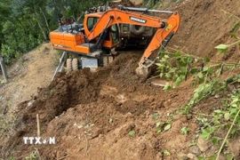 Các đơn vị tăng cường phương tiện máy công trình để khẩn trương thông tuyến. (Ảnh: TTXVN phát)