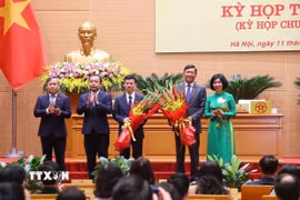 Lãnh đạo thành phố Hà Nội tặng hoa, chúc mừng tân Phó Chủ tịch Ủy ban Nhân dân thành phố Hà Nội Đỗ Anh Tuấn và Bùi Duy Cường. (Ảnh: Văn Điệp/TTXVN)