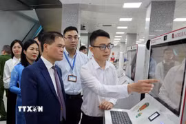 Ông Bùi Văn Khắng, Chủ tịch UBND tỉnh Quảng Ninh (bên trái), trải nghiệm Kiosk thông minh và hệ thống xác thực, cấp bản sao số, tài liệu điện tử đặt tại Trung tâm Phục vụ hành chính công tỉnh Quảng Ninh. (Ảnh: Đức Hiếu/TTXVN)