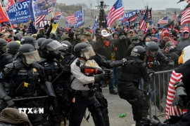Người biểu tình xung đột với cảnh sát chống bạo động tại Đồi Capitol ở Washington DC., ngày 6/1/2021. (Ảnh: AFP/TTXVN)
