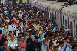 Người dân chen lấn chờ lên tàu hỏa tại nhà ga ở Mumbai, Ấn Độ. (Ảnh: AFP/TTXVN)