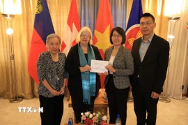 Đại sứ quán Việt Nam tại Thụy Sĩ nhận số tiền ủng hộ từ các tổ chức. (Ảnh: Anh Hiển/TTXVN)