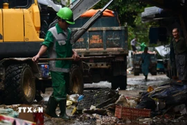 Anh Hoàng Toàn, công nhân của Công ty cổ phần Môi trường và Công trình đô thị Huế, cho biết đợt lũ này phát sinh lượng rác lớn, nên buộc phải tăng ca, làm ngày đêm với mong muốn sớm trả lại môi trường sạch đẹp. (Ảnh: Văn Dũng/TTXVN)