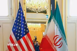 Quốc kỳ Mỹ (trái) và Iran tại một bàn đàm phán. (Ảnh: MNA/TTXVN)
