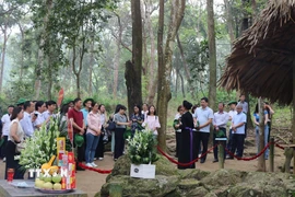 Du khách dâng hương và nghe thuyết minh tại lán Nà Nưa, Khu di tích Quốc gia đặc biệt Tân Trào, xã Tân Trào (Tuyên Quang). (Ảnh: Hoàng Hải/TTXVN)