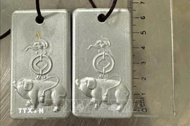 Hai miếng kim loại nghi là vàng do Lou Jiaqi vận chuyển trái phép vào Việt Nam. (Ảnh: TTXVN phát)