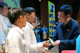 Chủ tịch Tập đoàn TKV Ngô Hoàng Ngân tặng quà cho công nhân. (Ảnh: Văn Đức/TTXVN)