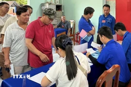 Đoàn viên, thanh niên phường Chơn Thành, tỉnh Đồng Nai hỗ trợ cử tri, hướng dẫn quy trình bầu cử, góp phần bảo đảm ngày bầu cử diễn ra thuận lợi, an toàn và đúng quy định. (Ảnh: Nhật Bình/TTXVN)