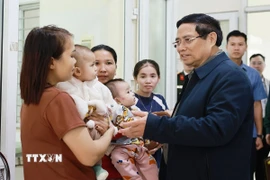 Thủ tướng Phạm Minh Chính với nhân dân đến khám, chữa bệnh tại trạm y tế xã Yên Khương. (Ảnh: Dương Giang/TTXVN)