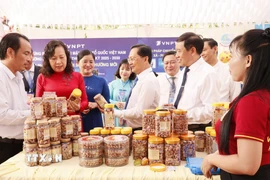 Lãnh đạo tỉnh Đồng Nai tham quan gian hàng đặc sản hạt điều rang muối của địa phương. (Ảnh: Nhật Bình/TTXVN)