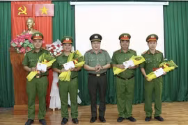 Đại tá Lâm Phước Nguyên, Giám đốc Công an tỉnh An Giang trao thưởng nóng Chủ tịch UBND tỉnh An Giang cho 4 tập thể. (Ảnh: TTXVN phát)