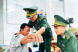 Quân y Đồn Biên phòng Gành Hào chăm sóc sức khỏe cho thuyền viên gặp nạn. (Ảnh: TTXVN phát)