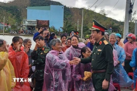 Bộ trưởng Bộ Quốc phòng Đại tướng Phan Văn Giang thăm hỏi người dân vùng lũ ở xã Tuy Phước. (Ảnh: Sỹ Thắng/TTXVN)