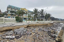 Nền đường giao thông quanh bờ kè Khu du lịch Hải Tiến bị đổ sập, để lộ phần chân móng trơ trọi. (Ảnh: Hoa Mai/TTXVN)