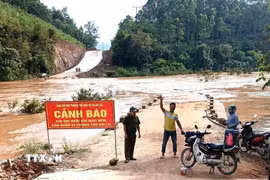 Lực lượng chức năng tổ chức cắm biển cảnh báo, bố trí chốt trực tại khu vực ngầm. (Ảnh: TTXVN phát)