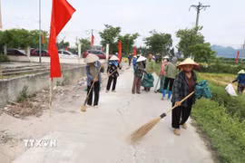 Cán bộ, hội viên Hội nông dân phường Yên Dũng, Bắc Ninh, tham gia quét dọn, thu gom rác thải, bảo vệ môi trường. (Ảnh: Việt Hùng/TTXVN)