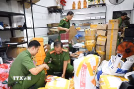 Công an thành phố Cần Thơ phối hợp Chi Cục quản lý thị trường thành phố Cần Thơ kiểm đếm, niêm phong số lượng lớn dép “giả” thương hiệu nổi tiếng tại cửa hàng T.D Luxury. (Ảnh: TTXVN phát)