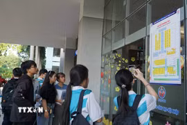 Thí sinh xem thông tin phòng thi đánh giá năng lực Đại học Quốc gia Thành phố Hồ Chí Minh tại điểm thi Trường Đại học Công nghệ Kỹ thuật Thành phố Hồ Chí Minh. (Ảnh: Thu Hoài/TTXVN)