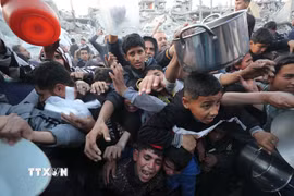 Người dân chờ được phát thực phẩm cứu trợ tại Gaza. (Ảnh: THX/TTXVN)