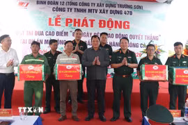 Thiếu tướng Nguyễn Hữu Ngọc, Tư Lệnh Binh đoàn 12 và Phó Chủ tịch Thường trực Ủy ban Nhân dân tỉnh Cà Mau Lâm Văn Bi tặng quà cho công nhân. (Ảnh: Tuấn Phi/TTXVN)