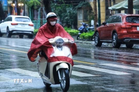 Mưa rét ảnh hưởng đến việc tham gia giao thông của người dân. (Ảnh: Tuấn Anh/TTXVN)