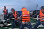 Các chiến sĩ giúp một tàu ngư dân bị nạn. (Ảnh: TTXVN phát)