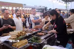 Du khách quốc tế chọn mua thưởng thức ẩm thực tại Lễ hội Đà Nẵng Food Tour 2025. (Ảnh: Trần Lê Lâm/TTXVN)