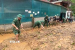 Cán bộ, chiến sỹ Đồn biên phòng Mường Ải (Nghệ An) giúp người dân địa phương dọn dẹp bùn đất, khắc phục hậu quả mưa lũ. (Ảnh: TTXVN phát) 