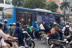 Hơn chục người nâng xe buýt để cứu nữ tài xế xe máy mắc kẹt tại Hà Nội