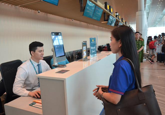 Hành khách thực hiện sinh trắc học nhận diện khuôn mặt trong quá trình làm thủ tục. (Ảnh: Linh Sơn/TTXVN) may-bay.jpg