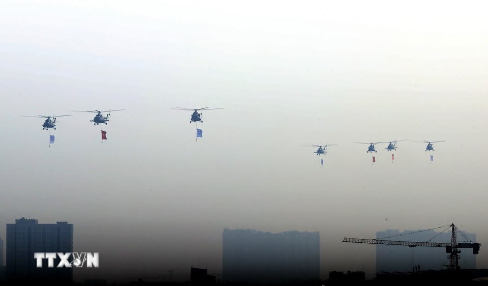 Biên đội trực thăng mang theo cờ Tổ quốc bay trình diễn tại lễ khai mạc Triển lãm Quốc phòng Quốc tế Việt Nam 2024. (Ảnh: Dương Giang/TTXVN)