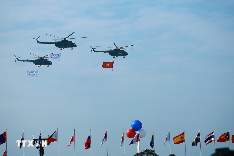 Biên đội trực thăng mang theo cờ tổ quốc bay trình diễn tại lễ khai mạc Triển lãm Quốc phòng Quốc tế Việt Nam 2024. (Ảnh: Dương Giang/TTXVN)