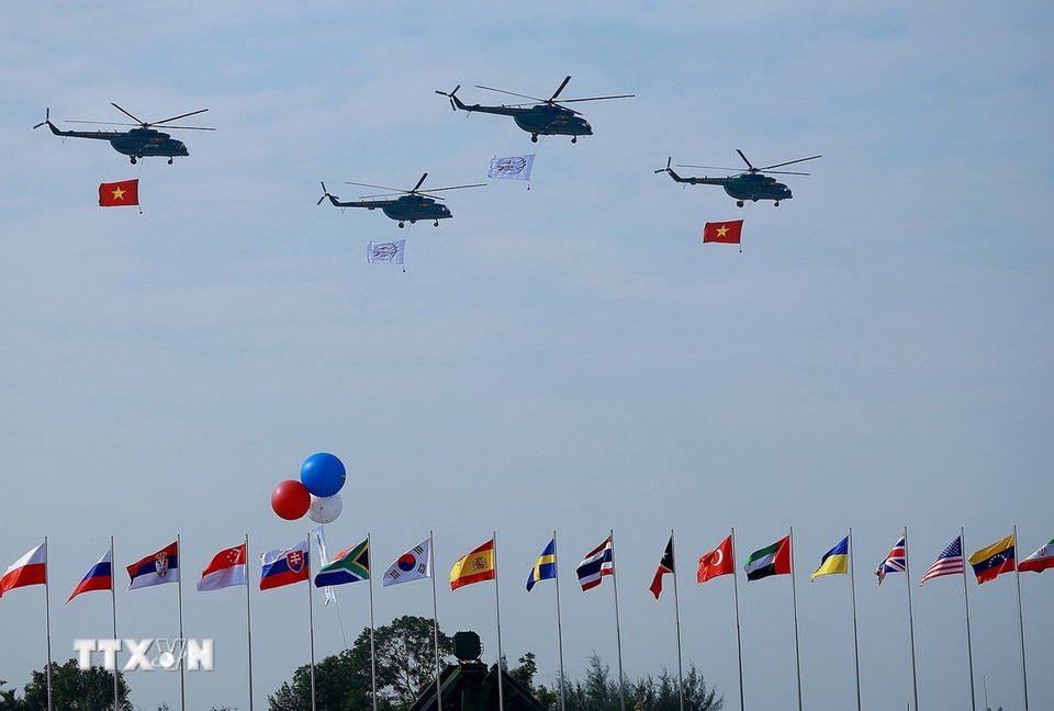 Biên đội trực thăng mang theo cờ Tổ quốc bay trình diễn tại lễ khai mạc Triển lãm Quốc phòng Quốc tế Việt Nam 2024. (Ảnh: Dương Giang/TTXVN)