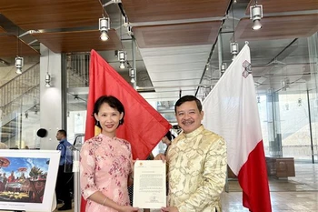 Đại diện Đại sứ quán Việt Nam tại Italy kiêm nhiệm Malta trao thư chúc mừng thành lập Hội người Việt Nam tại Malta của Thứ trưởng Ngoại giao Phạm Quang Hiệu cho Chủ tịch Hội Nguyễn Hoài Nam. (Ảnh: Dương Hoa/TTXVN)