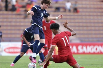 Pha tranh cướp bóng giữa cầu thủ Gomez (số 11, Guam) và cầu thủ Emaviwe (số 11, Singapore). (Ảnh: Minh Quyết/TTXVN)