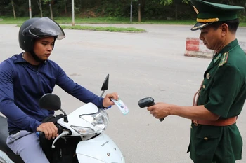 Cán bộ Trạm Kiểm soát Biên phòng cửa khẩu Chi Ma, tỉnh Lạng Sơn, quét thông tin trên thẻ mã QR đã cấp cho người ra vào khu vực cửa khẩu Chi Ma. (Ảnh: Quang Duy/TTXVN)
