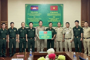 Đại tá Trần Tiến Hải, Chỉ huy trưởng Bộ đội Biên phòng tỉnh Gia Lai trao tặng kinh phí cho các lực lượng bảo vệ biên giới của tỉnh Ratanakiri, Vương quốc Campuchia. (Ảnh: TTXVN phát)